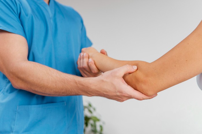 Orthopedic doctor examining a patient’s arm, symbolizing expert care by the best ankle and foot specialist in Greater Noida